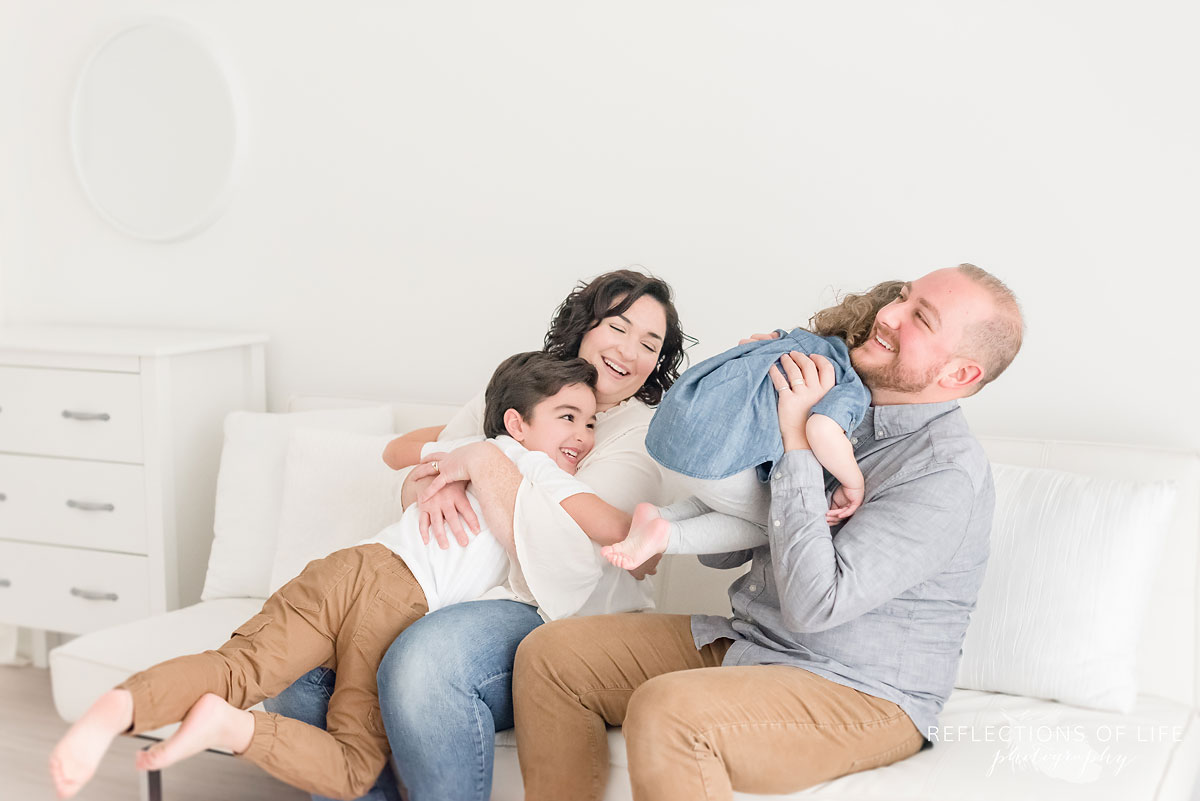 family hugging in white studio