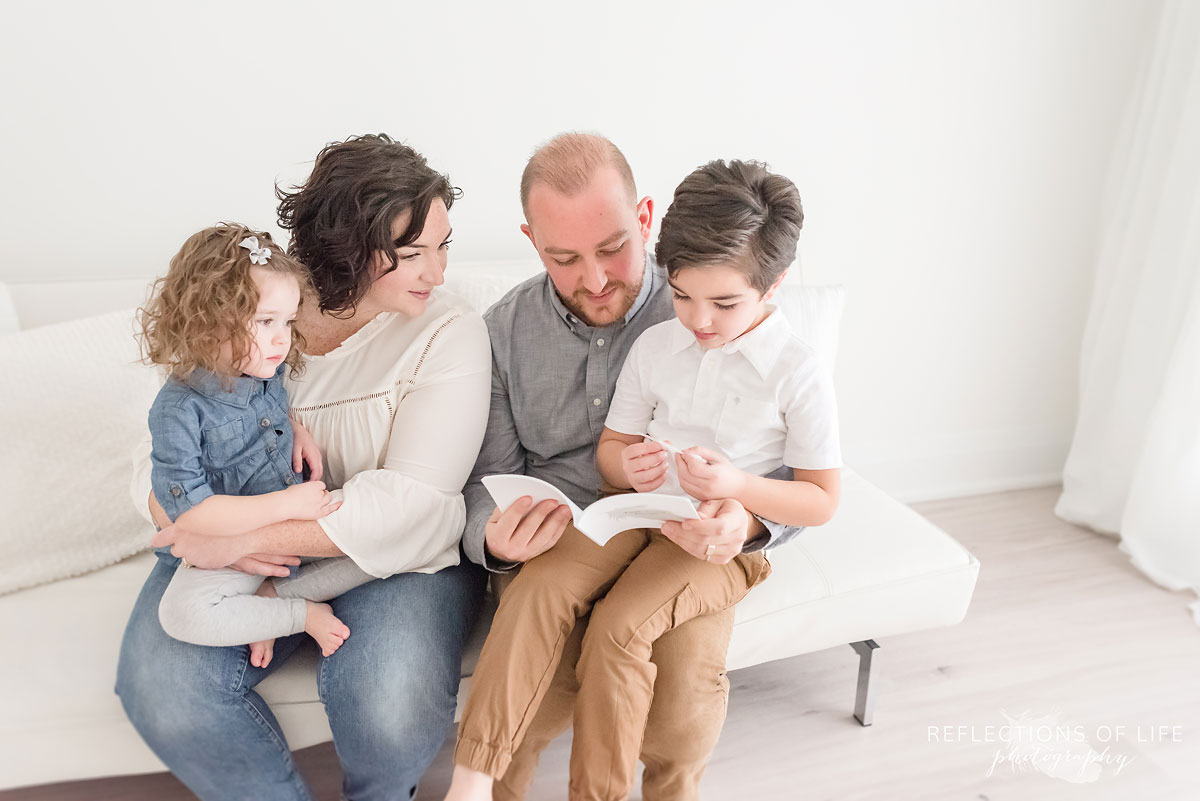 family reading on white couch