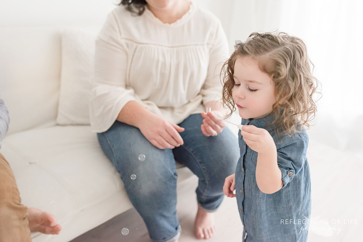 little girl blowing bubbles
