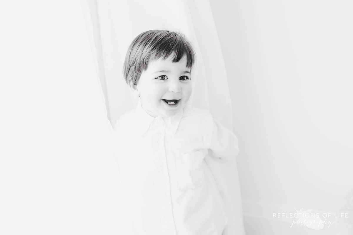 Little boy in white curtains