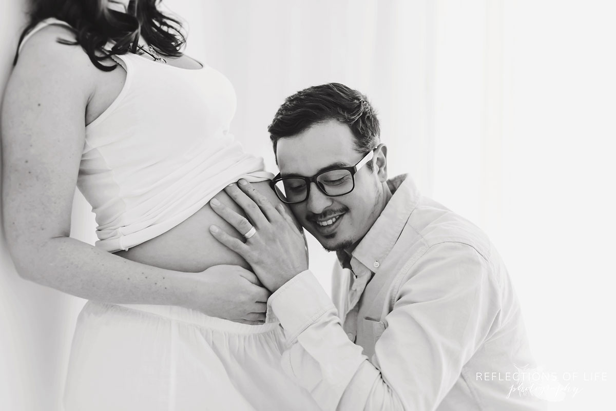 dad listening to wifes belly