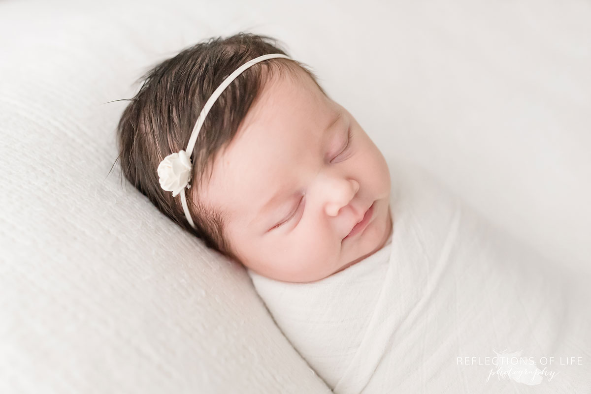 little newborn baby girl with pretty rose headband.jpg