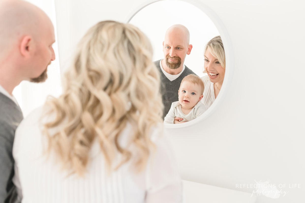 Copy of Copy of Baby boy looking into a mirror with his parents in Grimsby Ontario studio
