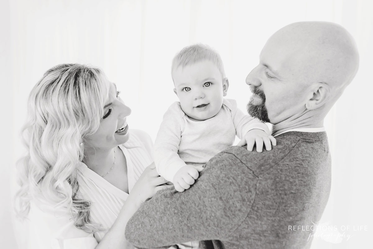 Copy of Copy of Baby boy laughing and playing with his parents in black and white