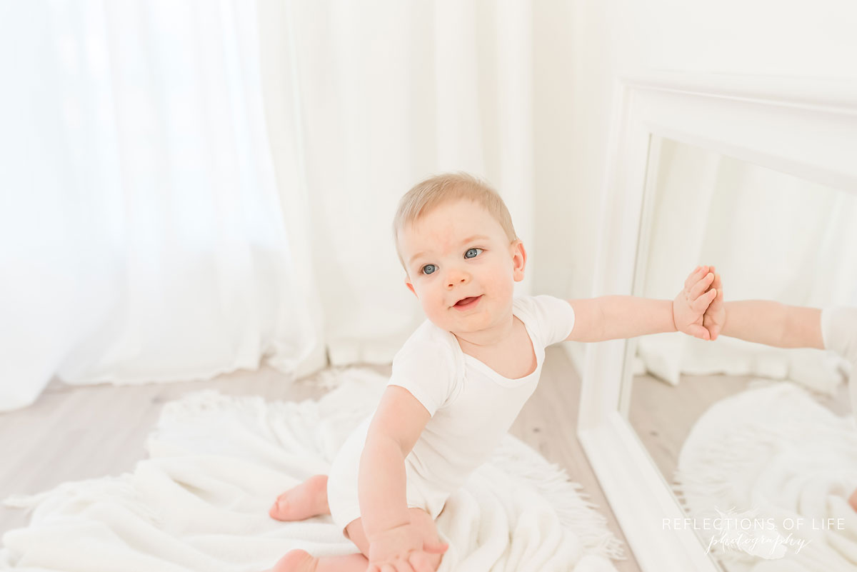 Copy of Copy of Little boy with hand on a mirror smiling