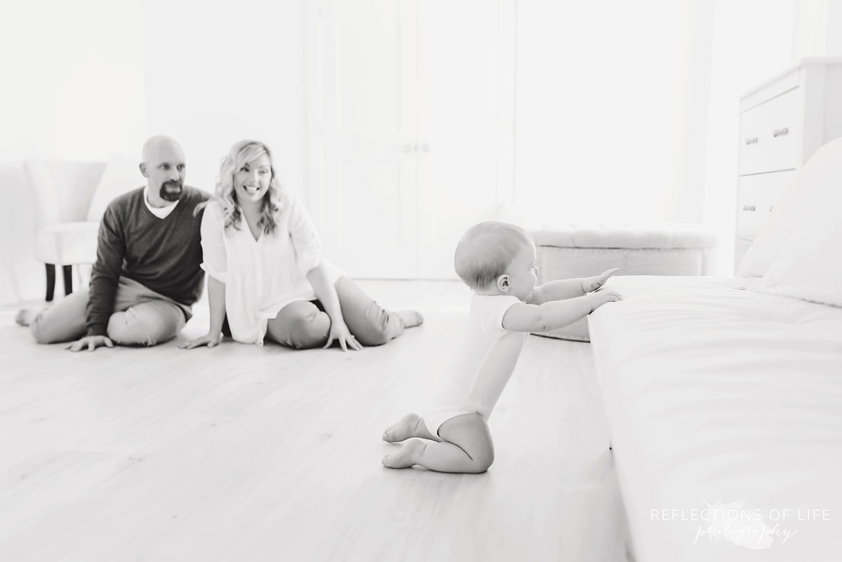 Copy of Copy of Fun family photos baby boy in onesie learning how to cruise across the couch