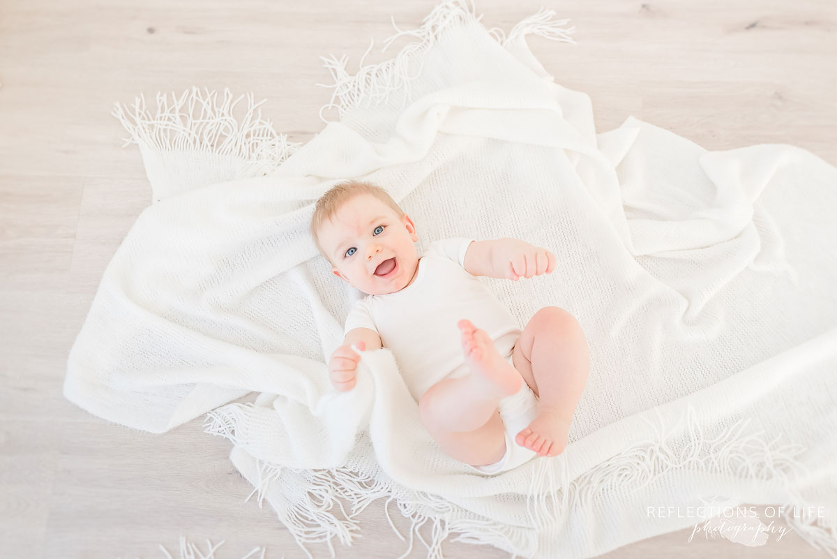 Copy of Copy of Baby boy playing in the floor with soft white blankets