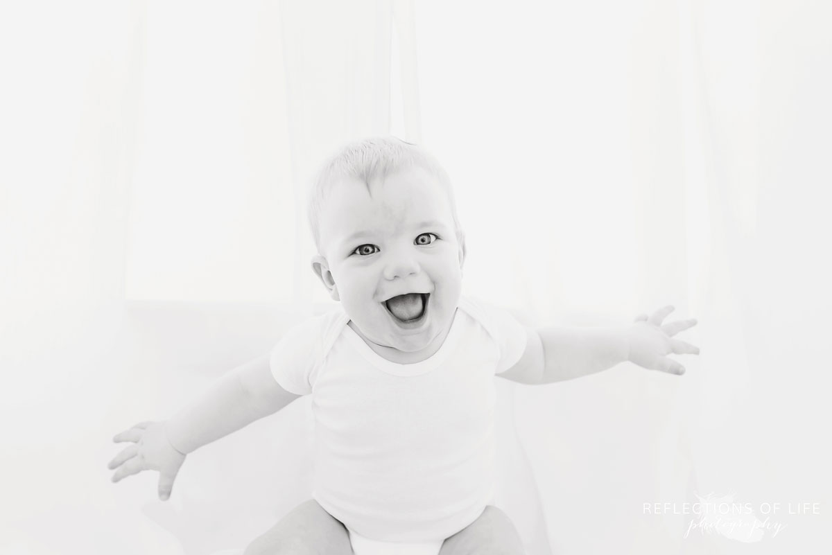 Copy of Copy of Baby boy laughing in the white curtains backlit