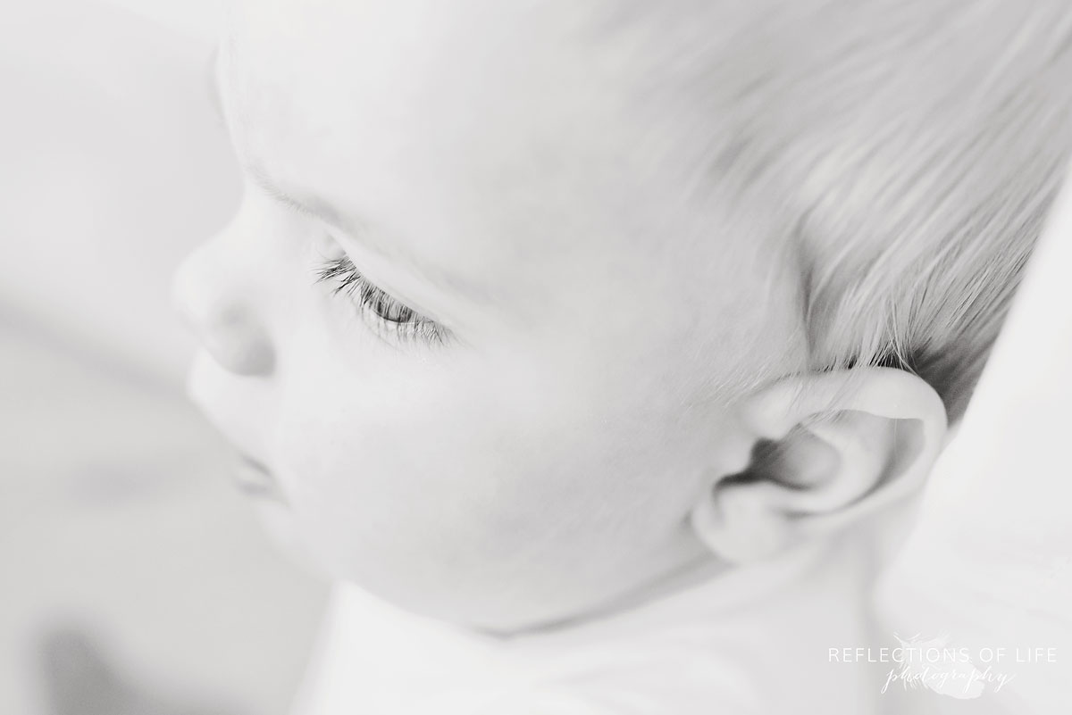 Copy of Copy of Baby boy looking out the window in black and white