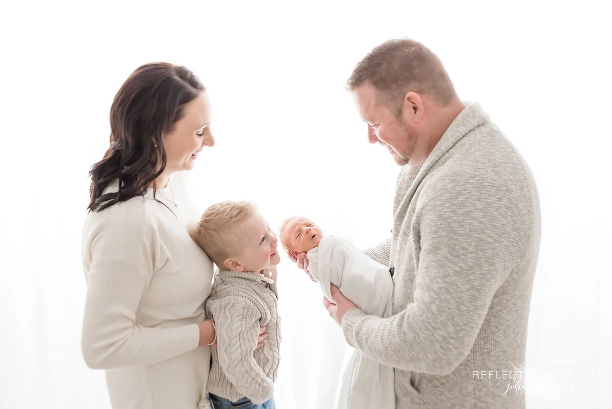 Portrait of Family holding newborn baby backlit.jpg