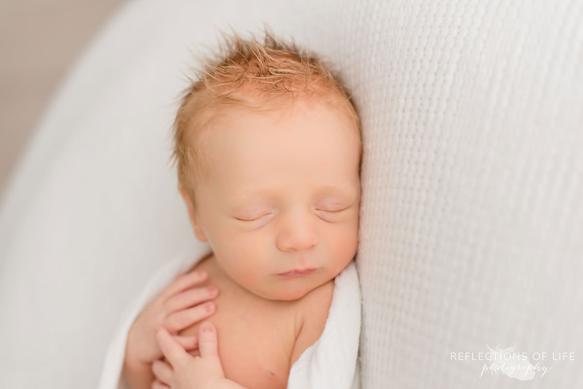 Newborn baby boy sleeping on white bouclair wonder blanket.jpg