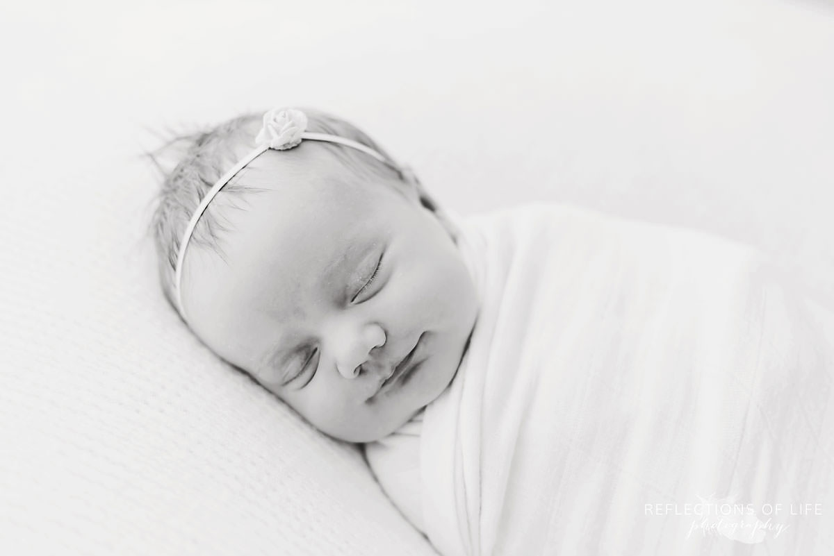 Adorable baby smiles while sleeping in black and white