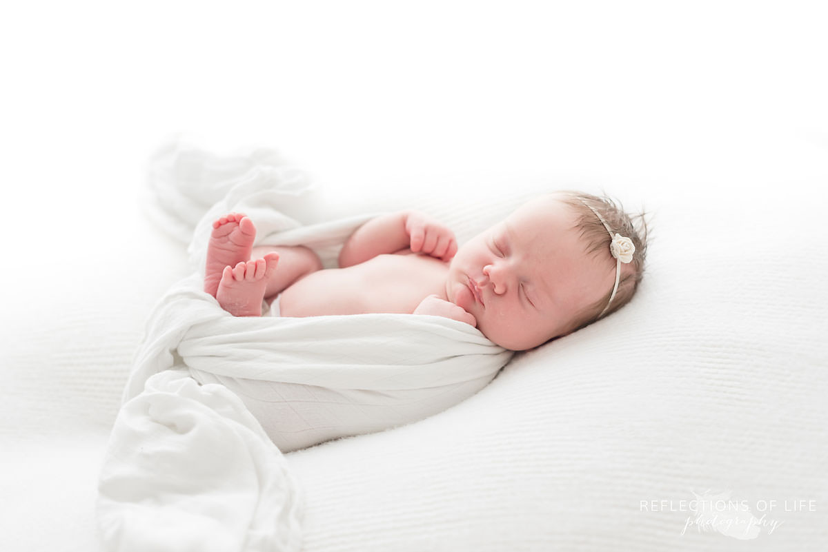 Sleeping baby with its hands and feet exposed in Grimsby