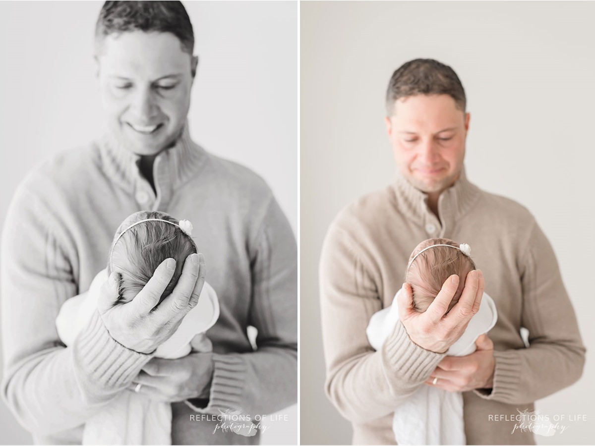 father holds child's head in hand in black and white