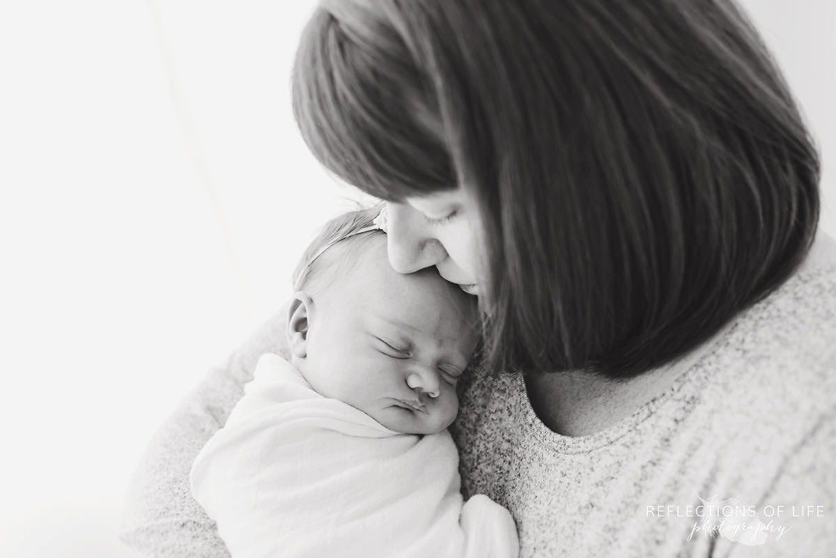 mother cuddles with her newborn baby in Ontario