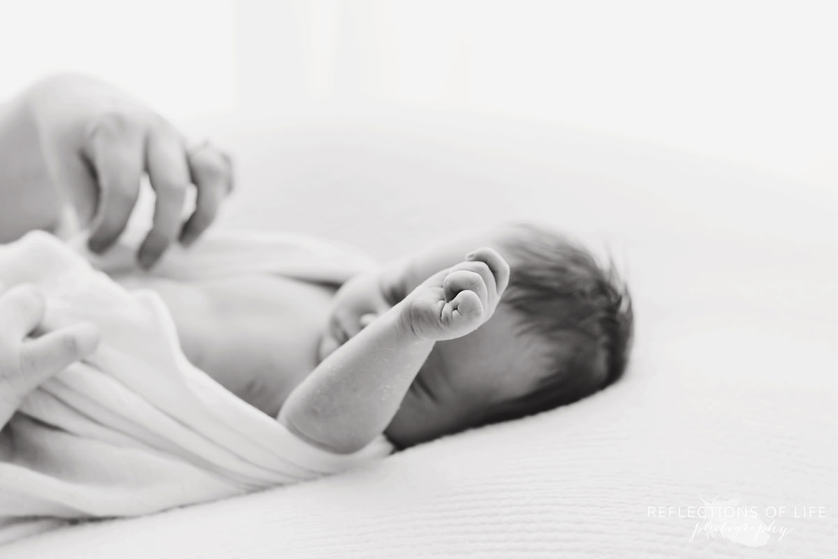 Mother fixing her baby's blanket in black and white