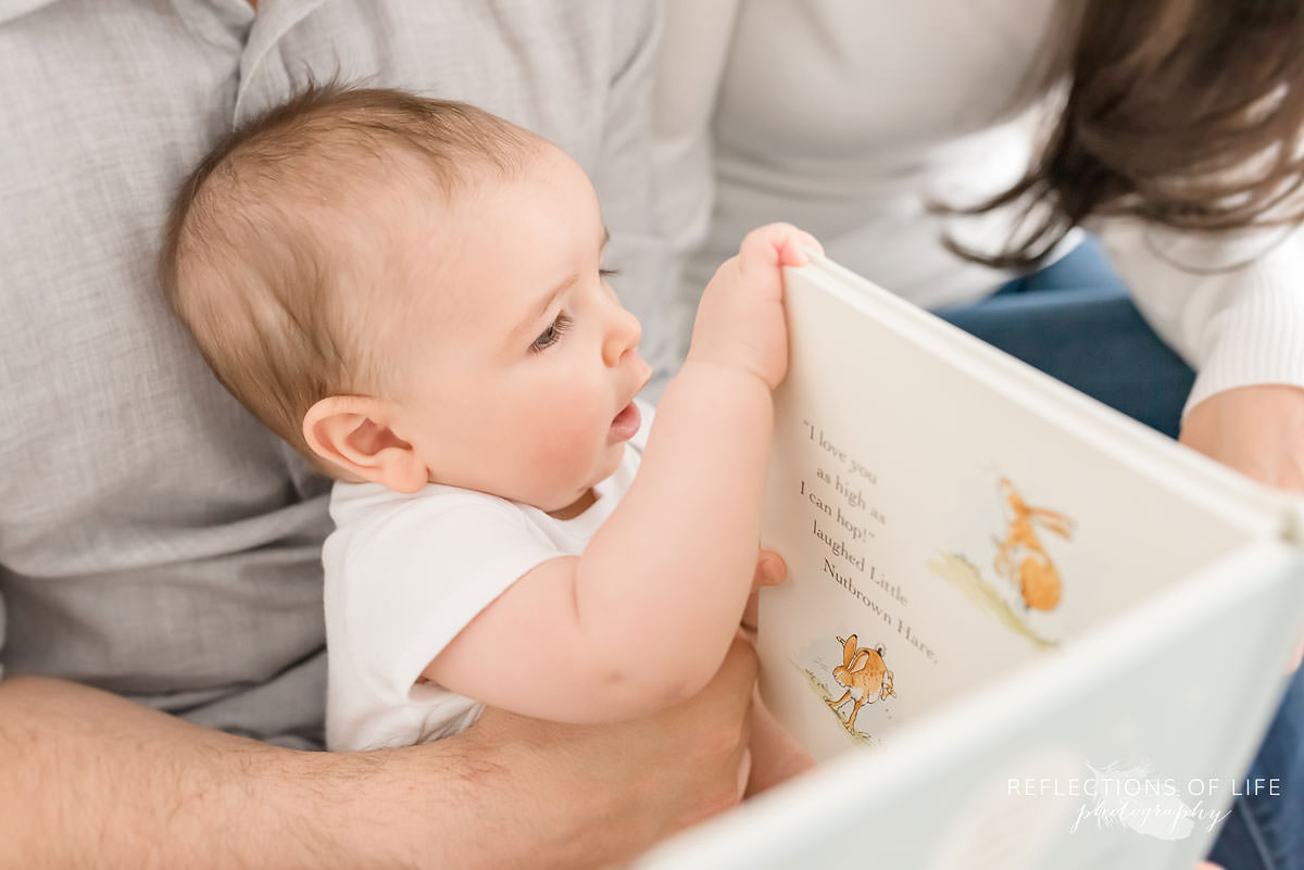 baby closes book that parents were reading with him in ontario
