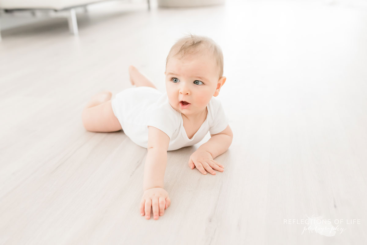 baby lays on ground attempting to crawl in ontario