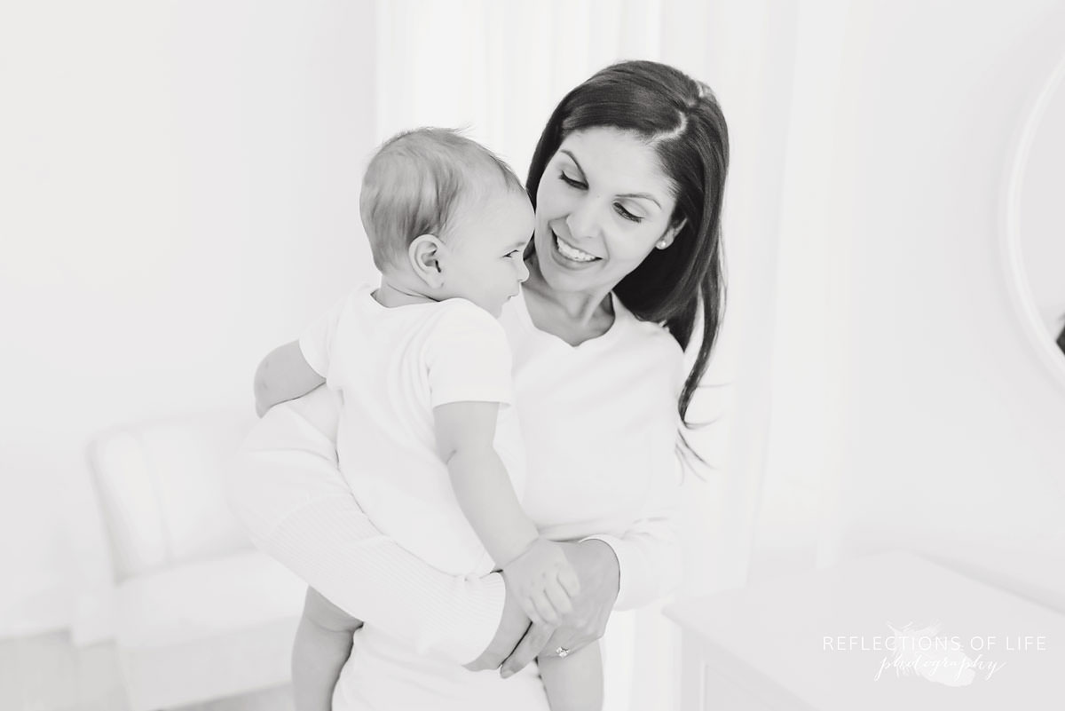 mother smiles at baby in black and white