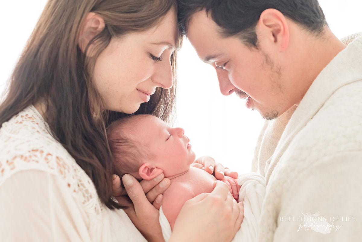 family of three cuddle and smile at eachother in niagara.jpg