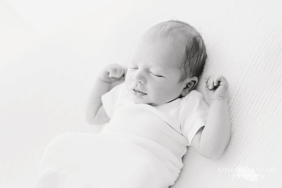 Sweet baby sprawled while relaxed in black and white
