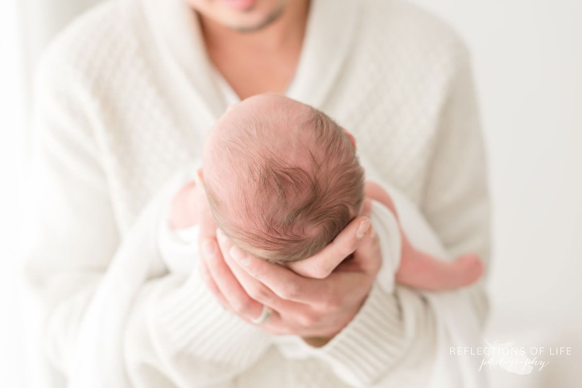 father holds his baby with it's head being in focus in grimsby