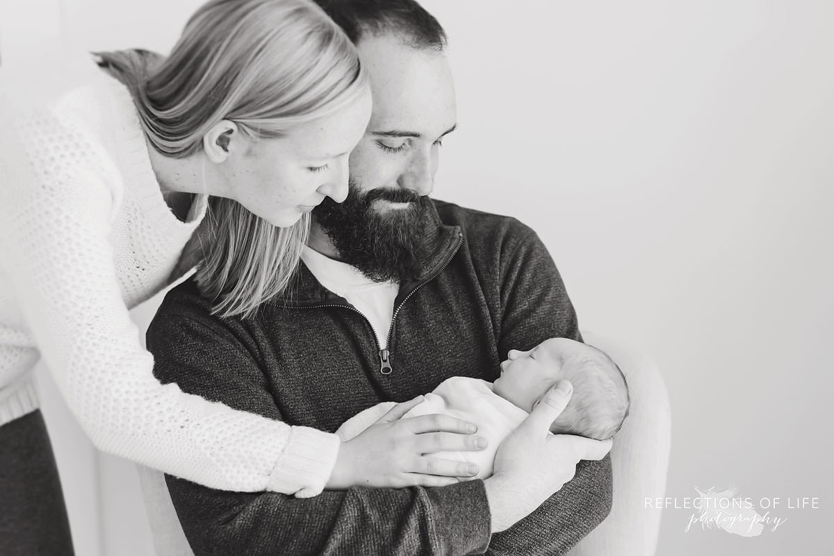 Mother and father admire their baby in black and white