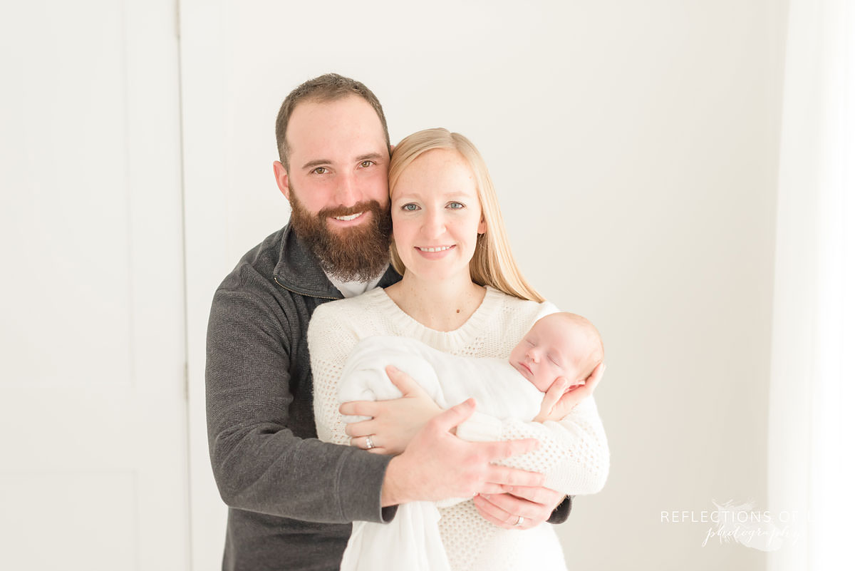 family of three smile all hugging each other in ontario