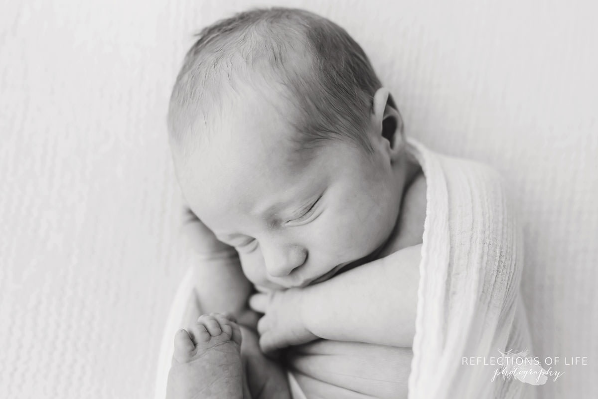 baby curled up cozy in black and white