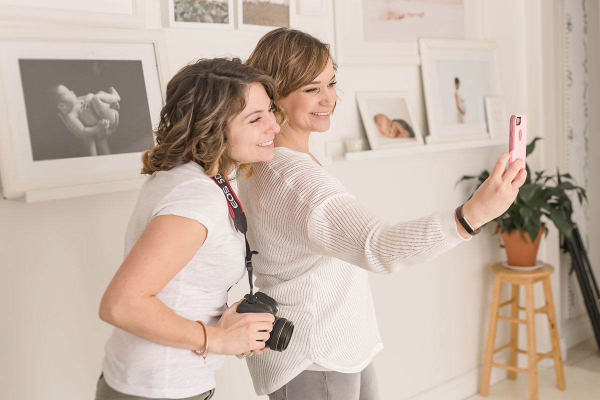 kayla and karen take a selfie in a natural light studio