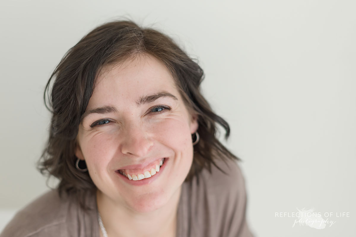 newborn photographer smiles at the camera in ontario