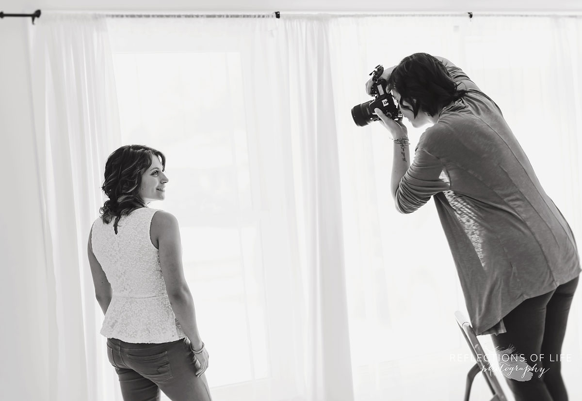 behind the scenes of photographer standing on ladder to photograph kayla