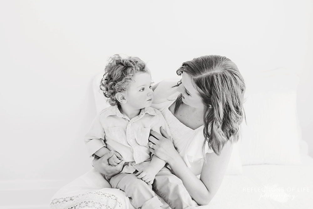 Mother smiles at son in black and white