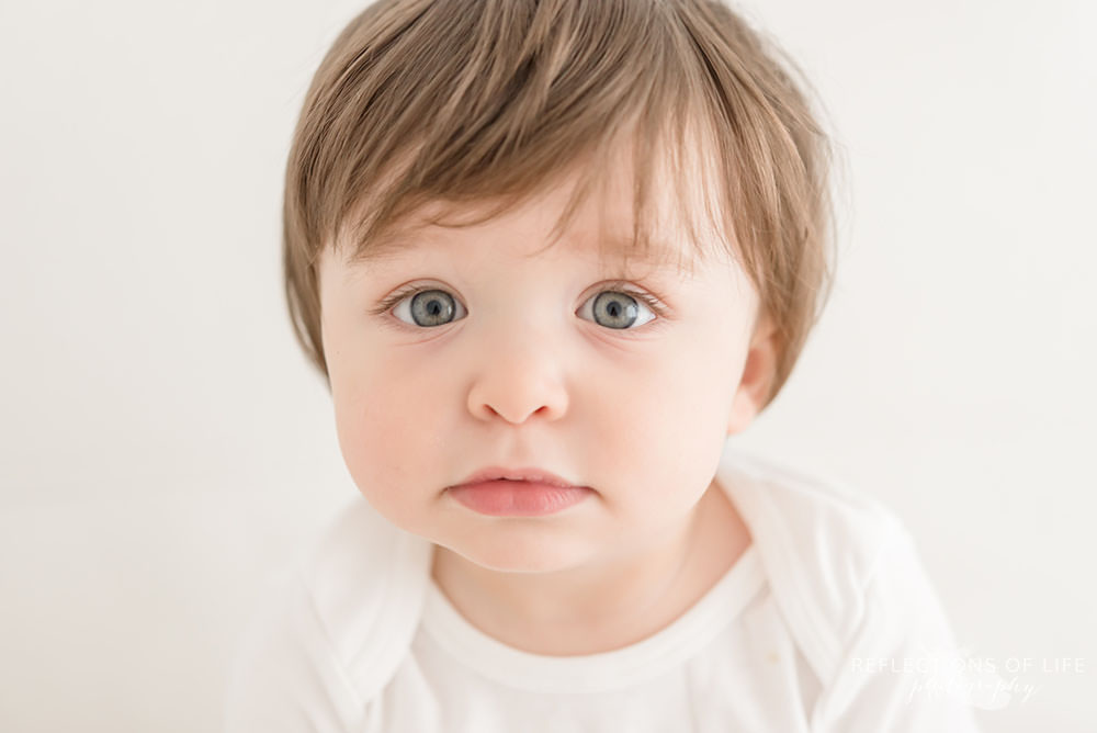 adorable toddler looks at the camera in natural light studio