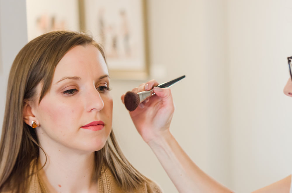 pretty lady gets her blush done by makeup artist