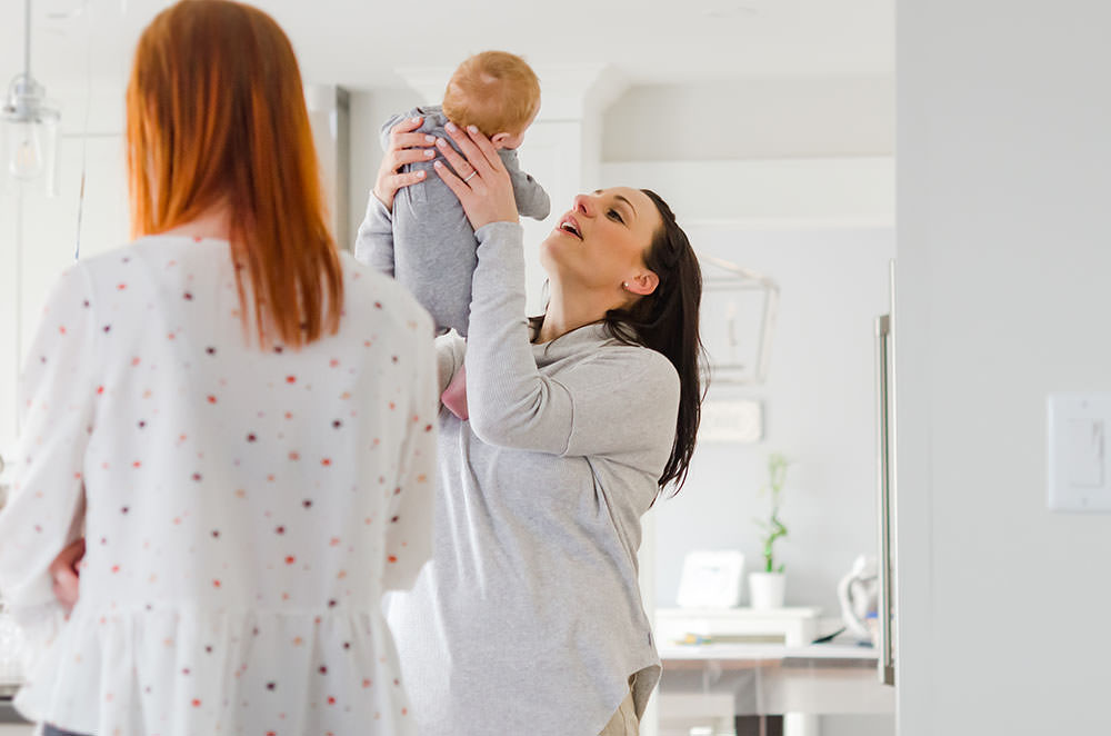 mama holds her baby up in the air in grimsby