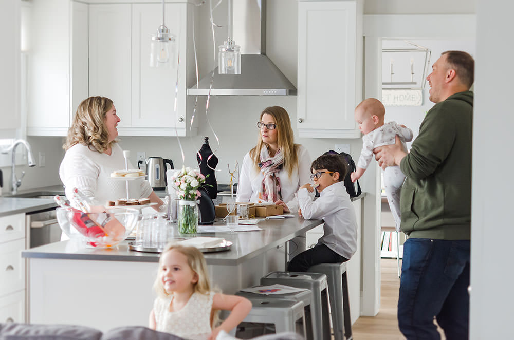 people socialize in the kitchen at the motherhood event
