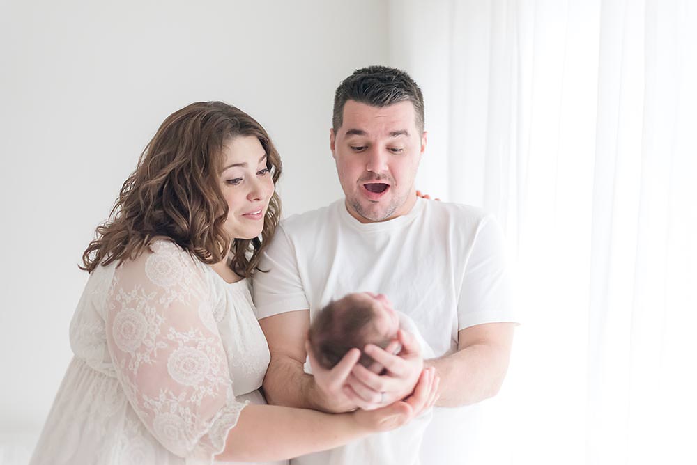 parents look suprised while looking at their baby