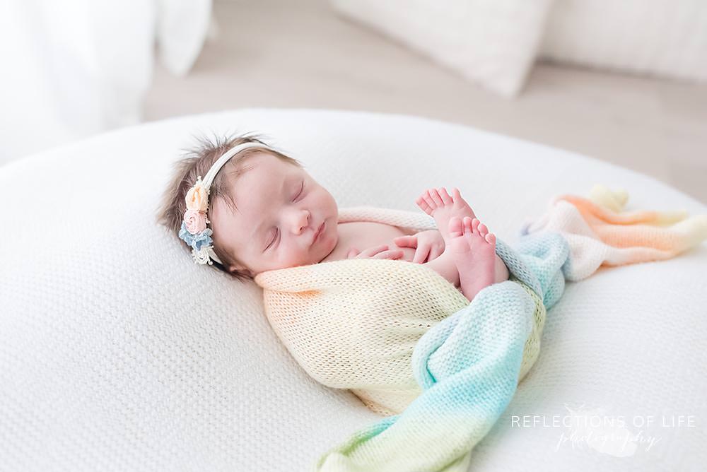 baby sleeps in rainbow scarf