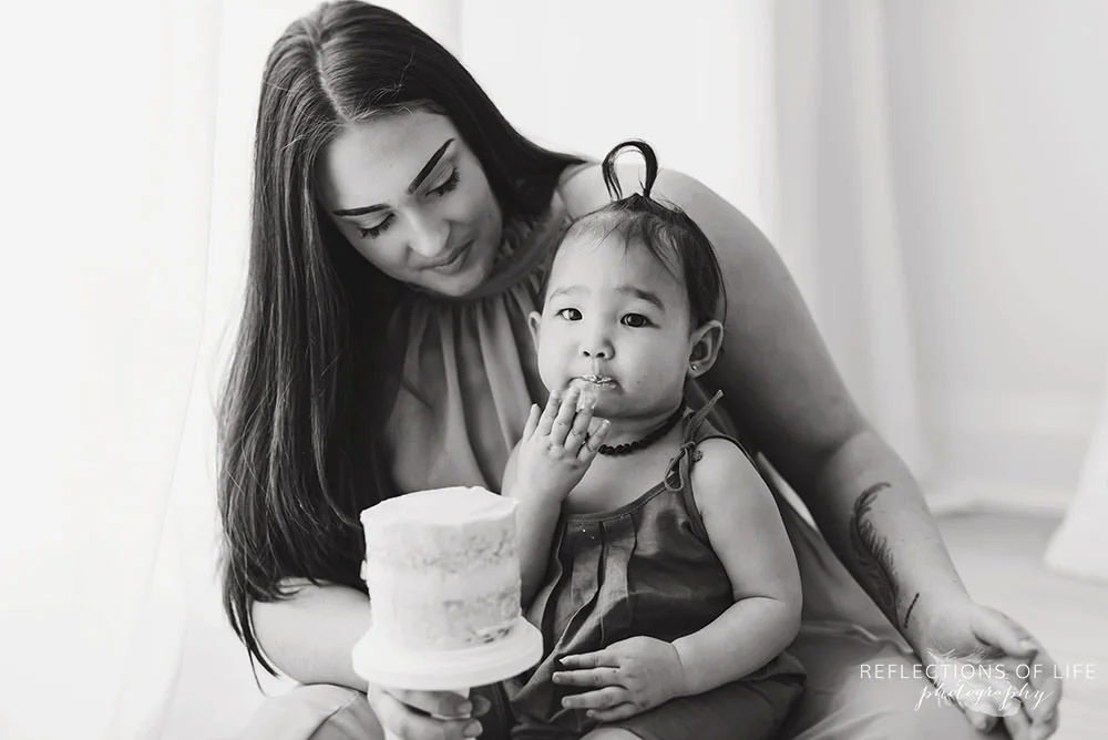 baby eats a handful of frosting in black and white