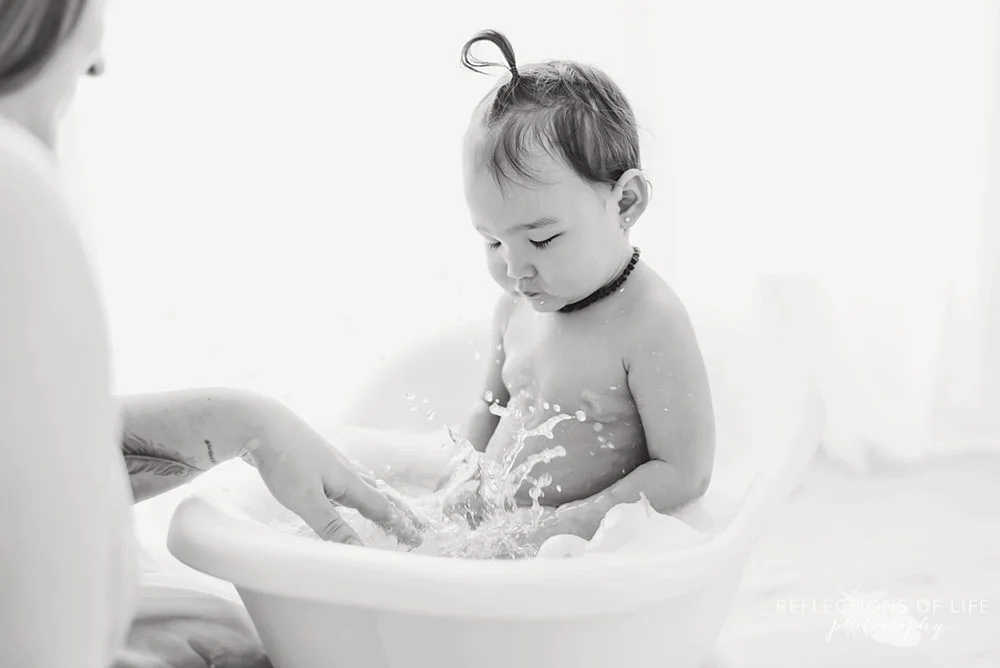 mama splashes baby in black and white