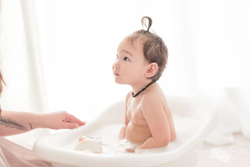 baby looks up at her mama in natural light studio