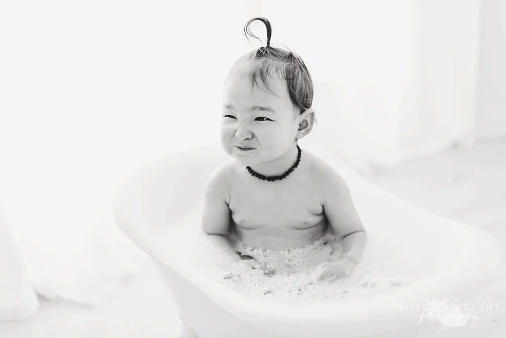little girl scrunches up her nose in black and white