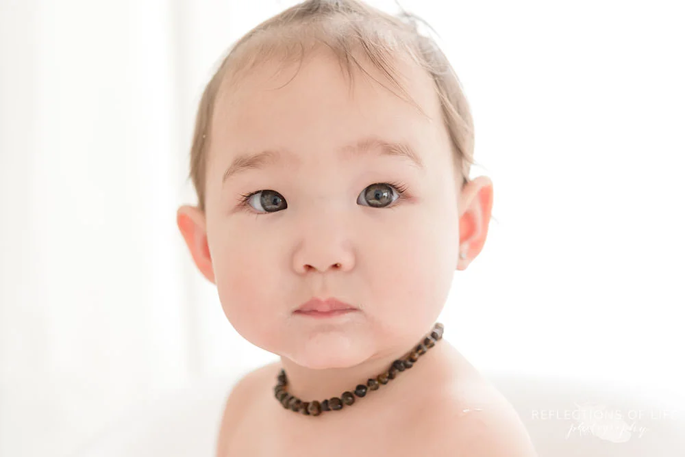 baby looks around the room in natural light studio