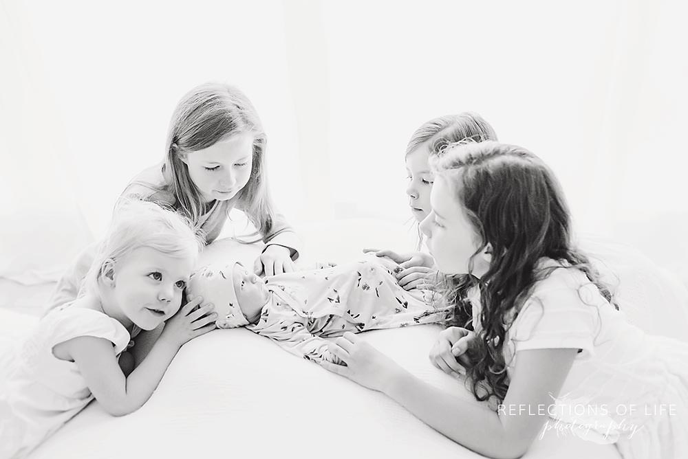 five sisters cuddle each other in black and white