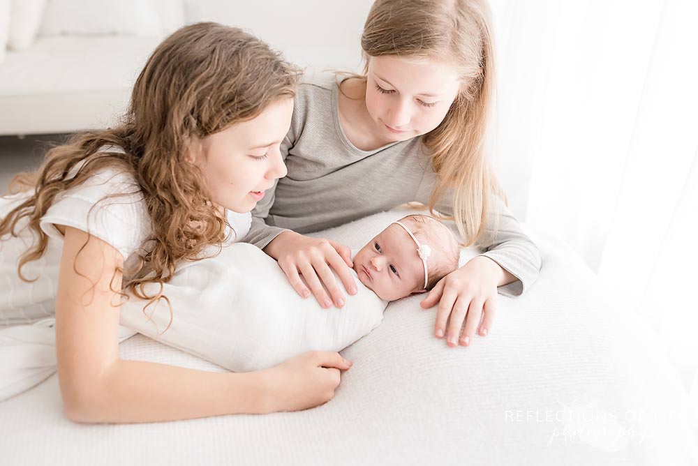 three sisters all share a moment of love on a bean bag