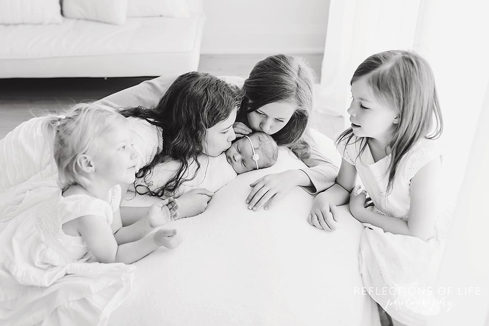 five sisters all kiss and smile at each other in black and white