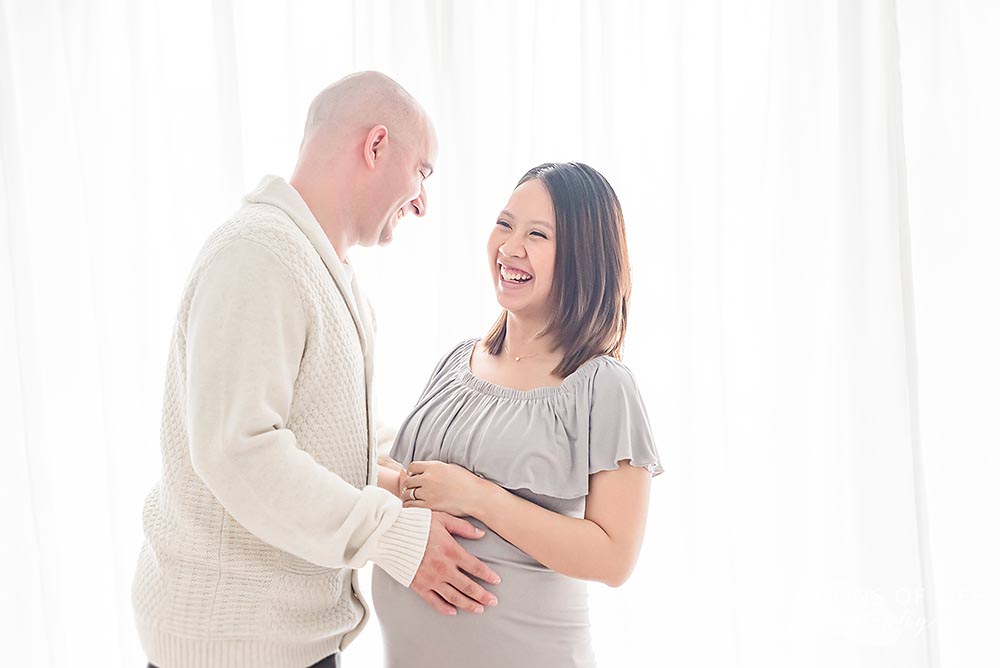couple shares a laugh in natural light studio