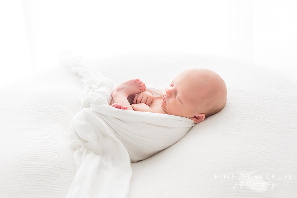 newborn is cozy in white natural light studio
