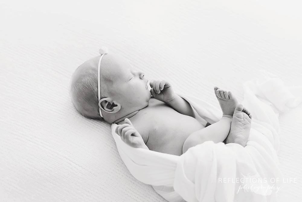 baby girl unwraps herself in black and white